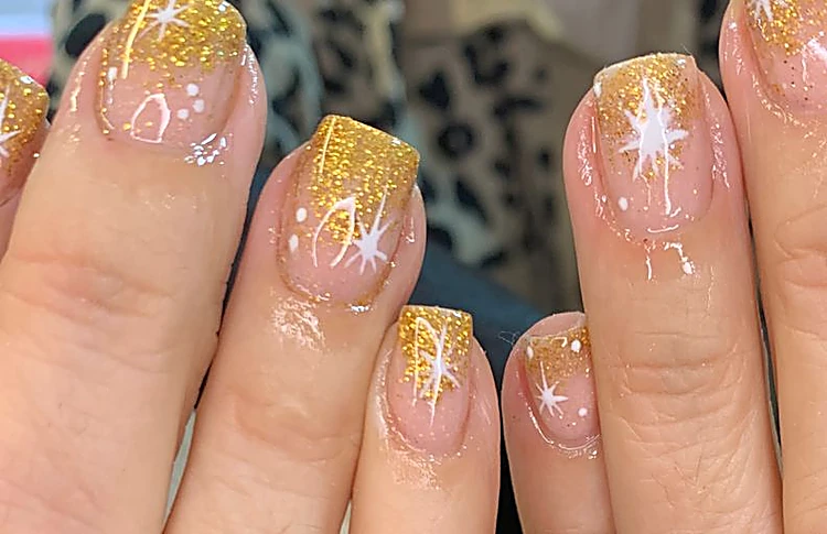 Acercamiento a las puntas doradas con estrellas blancas pintadas a mano.